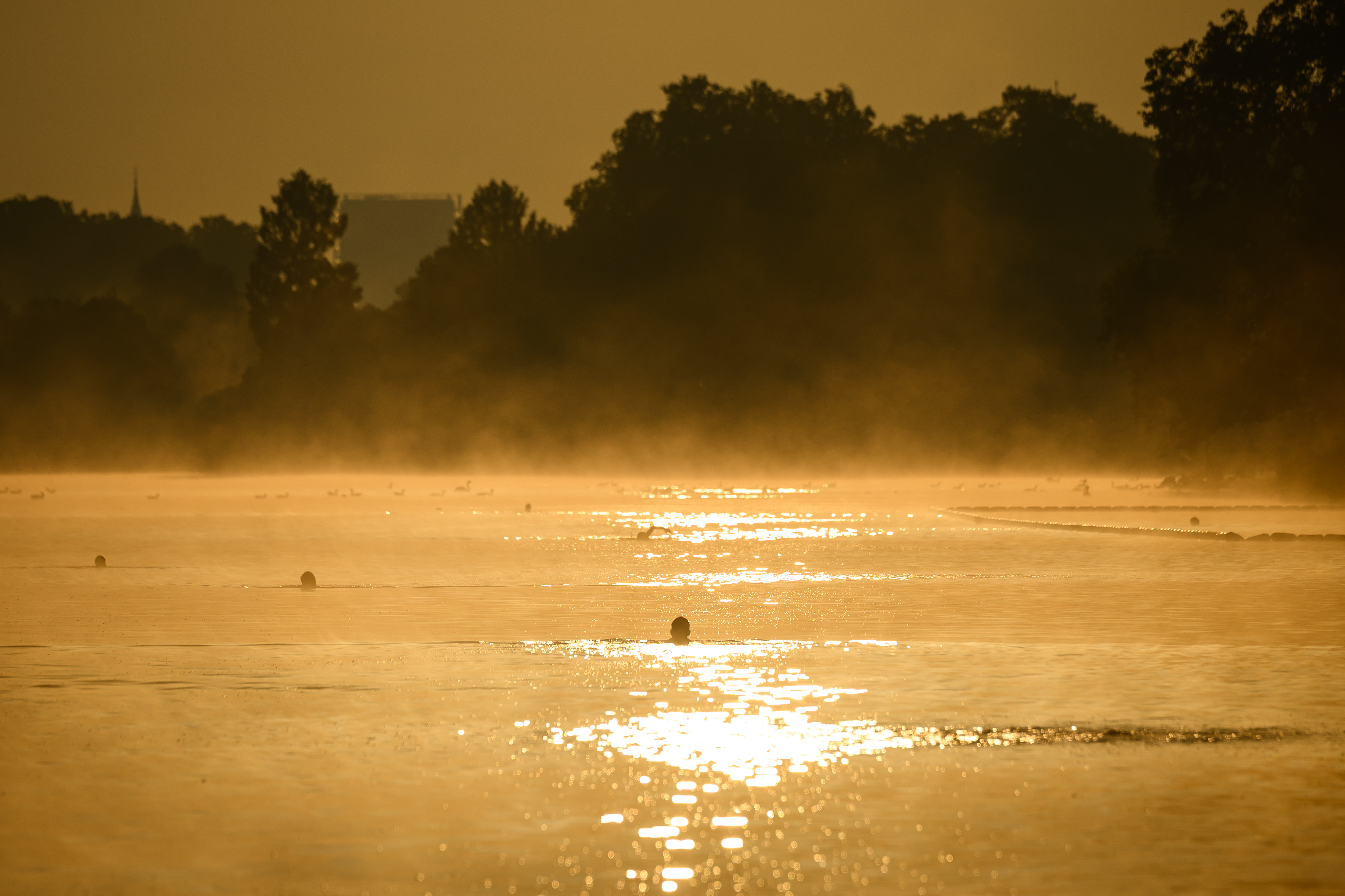 People take an early morning swim in the Serpentine on September 29, 2025 in London