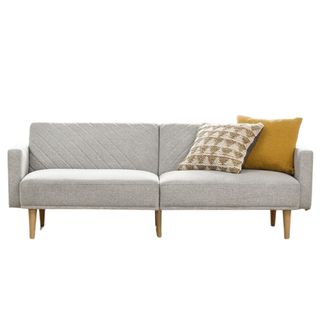 A gray futon couch with yellow pillows