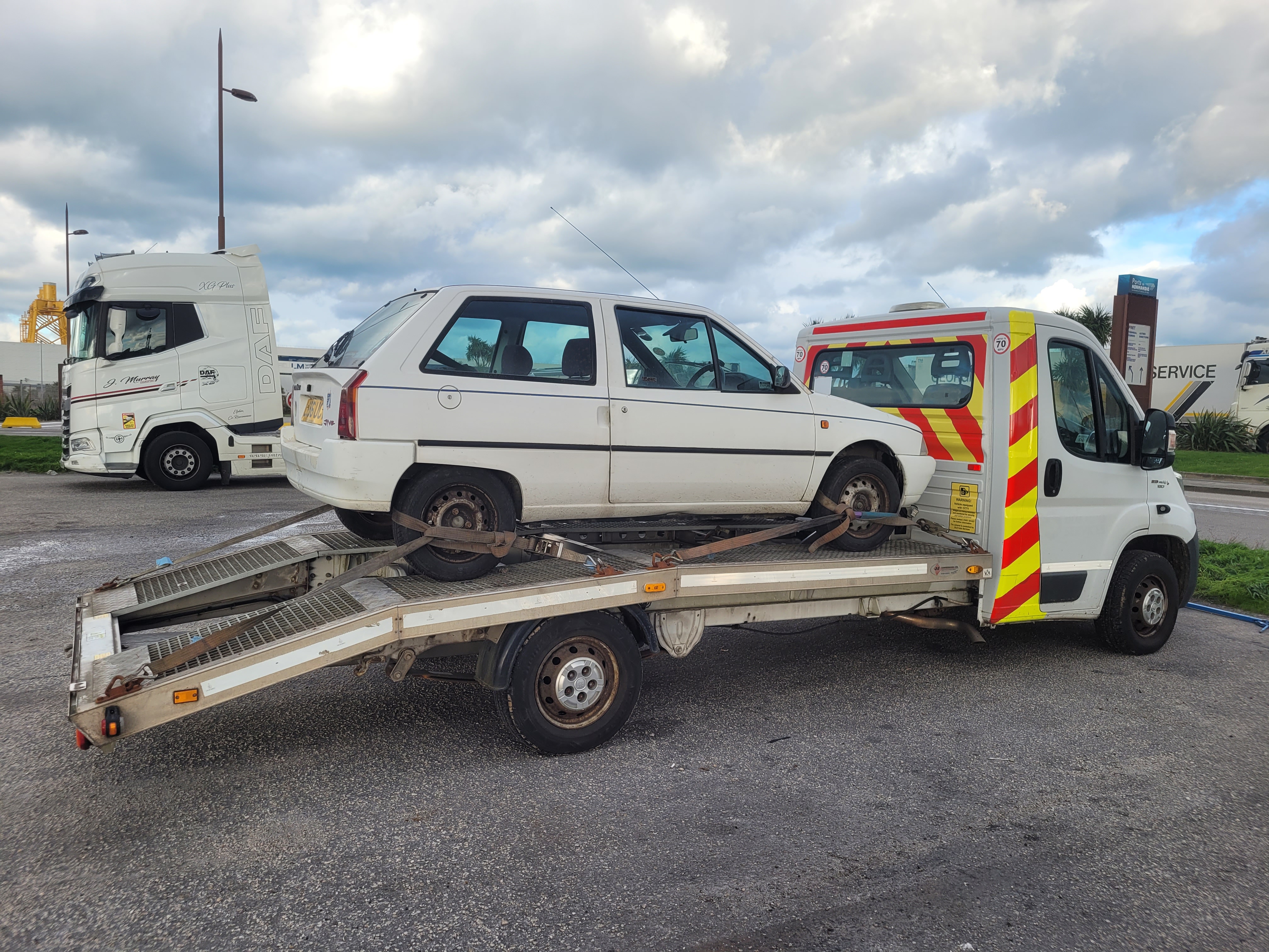 A knackered old white Citroen AX. It looks like a rusty metal box