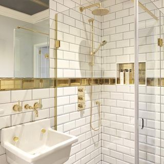 bathroom with white monochrome wall and golden pipe fittings