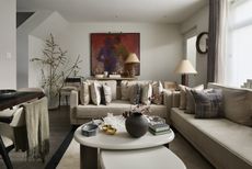 small living room with neutral couch and lots of taupe pillows