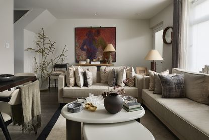small living room with neutral couch and lots of taupe pillows