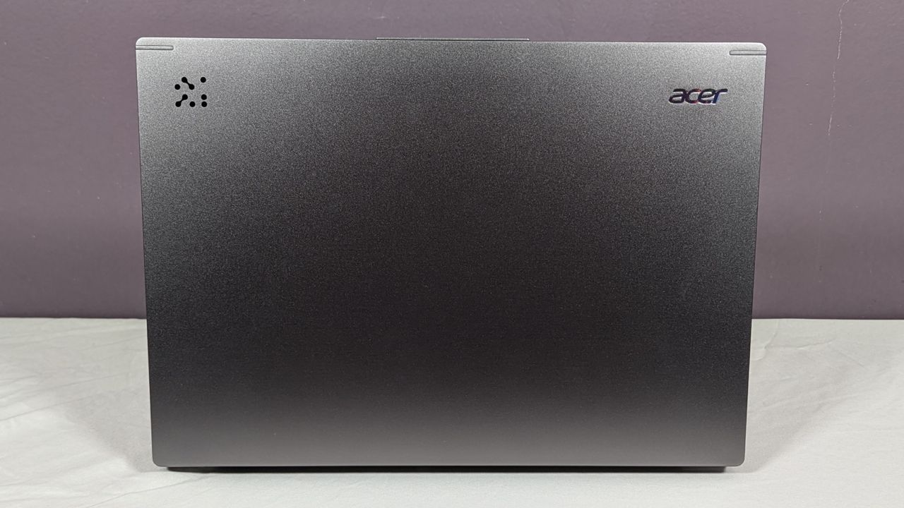 Acer Aspire 14 AI facing away on a white table against a gray background.