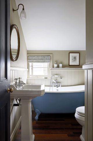 panelled bathroom with blue bath