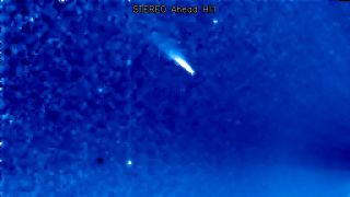 a comet appears as a white streak on a blue background