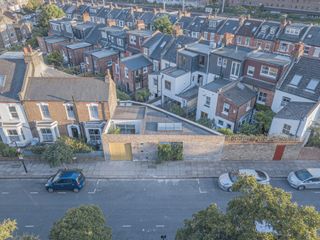 triangle house and its open space, large windows and courtyard with planting all designed by brown urbanism