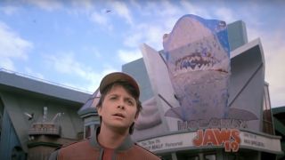 Michael J. Fox stands confused in front of a future theater in Back To The Future: Part II.