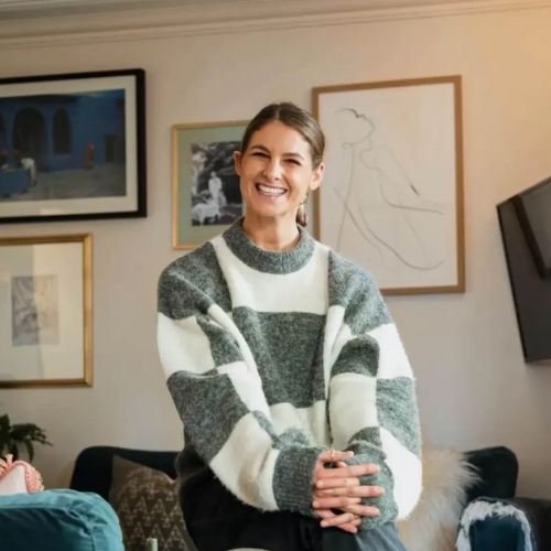 Image of a woman in a green and white checkerboard sweater sitting with her hands together.