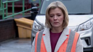 Leanne looks sad in a high vis vest