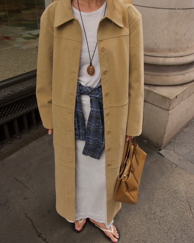 @chloekathbutler wears a tartan shirt tied around over waist over a cream maxi dress and finished with a butter yellow suede coat