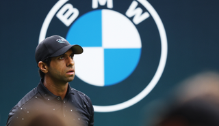 Aaron Rai walks off the tee with a BMW logo behind him