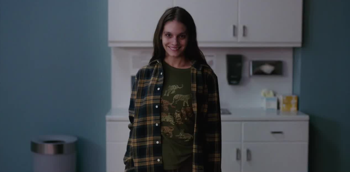 Smile star Caitlin Stasey as Laura Weaver, grinning at the camera