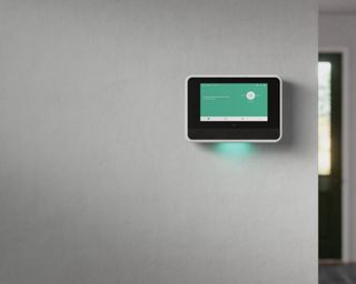 a security home hub on a wall with a color screen