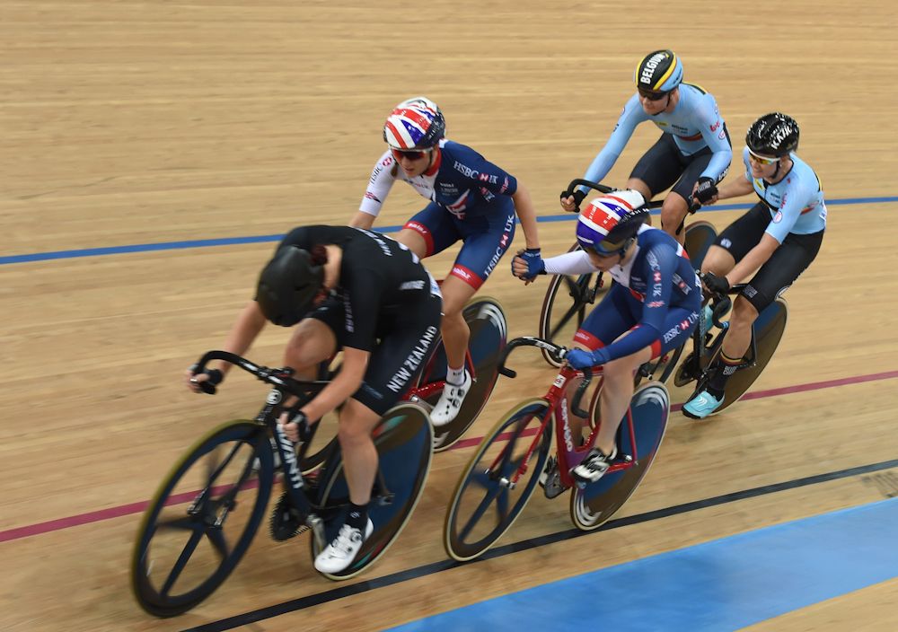 The Belgium (back) and Britain team (C) join hands during the women's madison final at the Hong Kong Velodrome during the Track Cycling World Championships