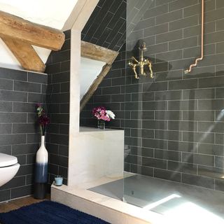bathroom with grey tiles on wall and flower pot