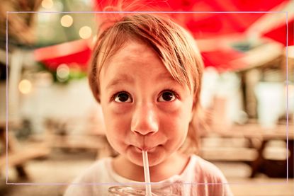 child drinking through a straw