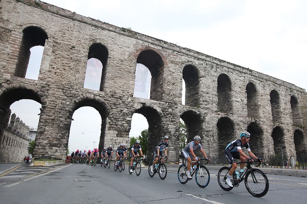 The peloton passing under a Roman aqueduct