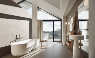 Guestroom bathroom with free standing bath & large windows