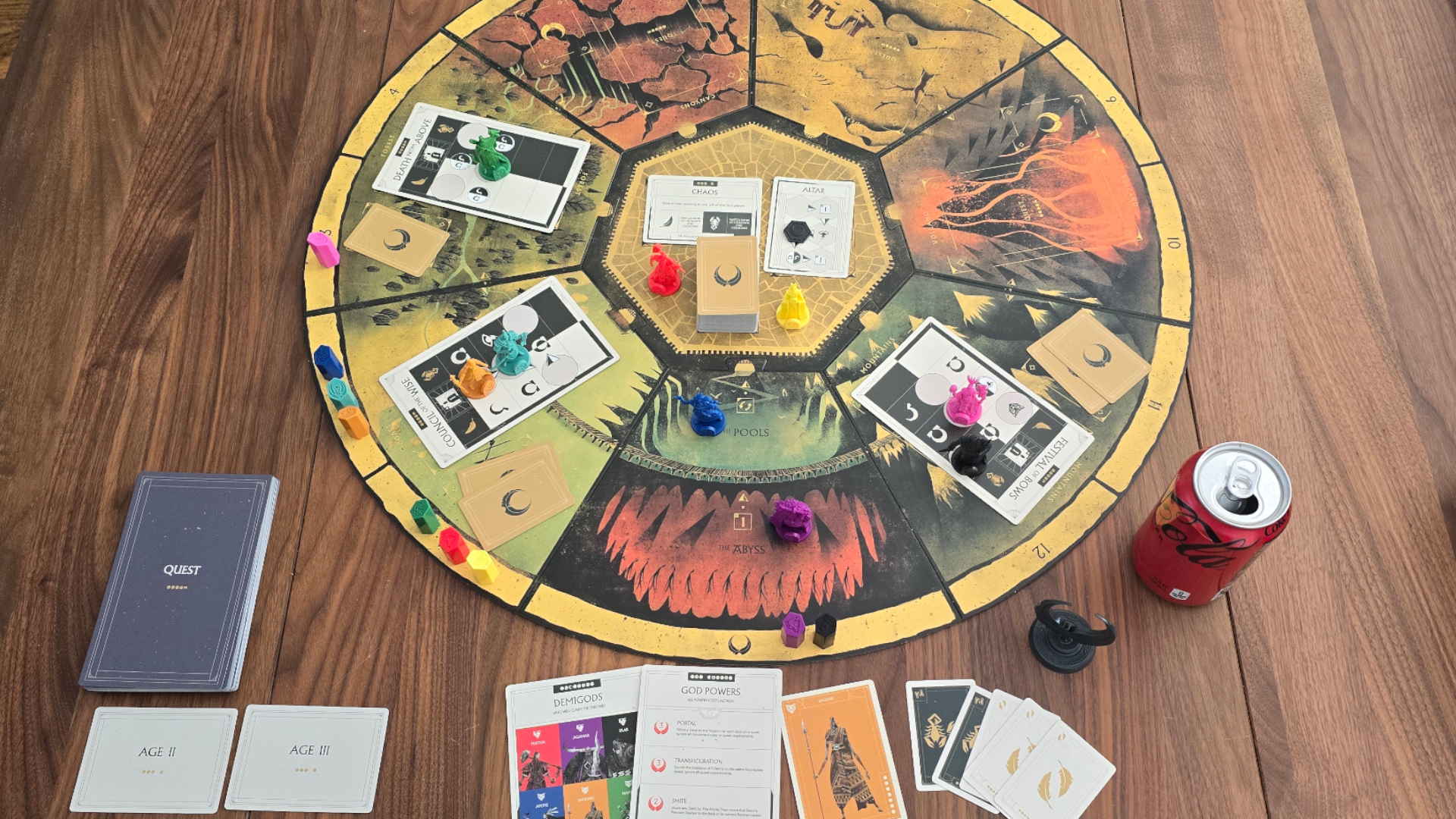 Veiled Fate board, cards, and tokens set up on a wooden table, with a can of Coke visible to one side