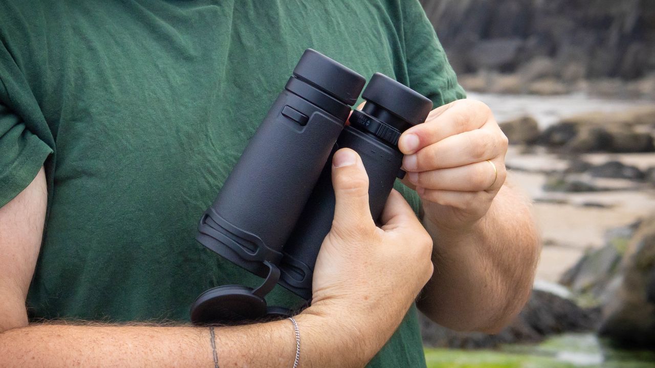 A person demonstrating the adjustable eyecups on the Nikon Monarch M7 8x42 binoculars.