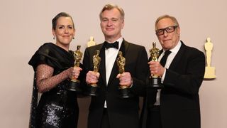 Emma Thomas, Christopher Nolan y Charles Roven posan con cuatro de los siete trofeos Oscar de Oppenheimer durante una sesión de fotos oficial.