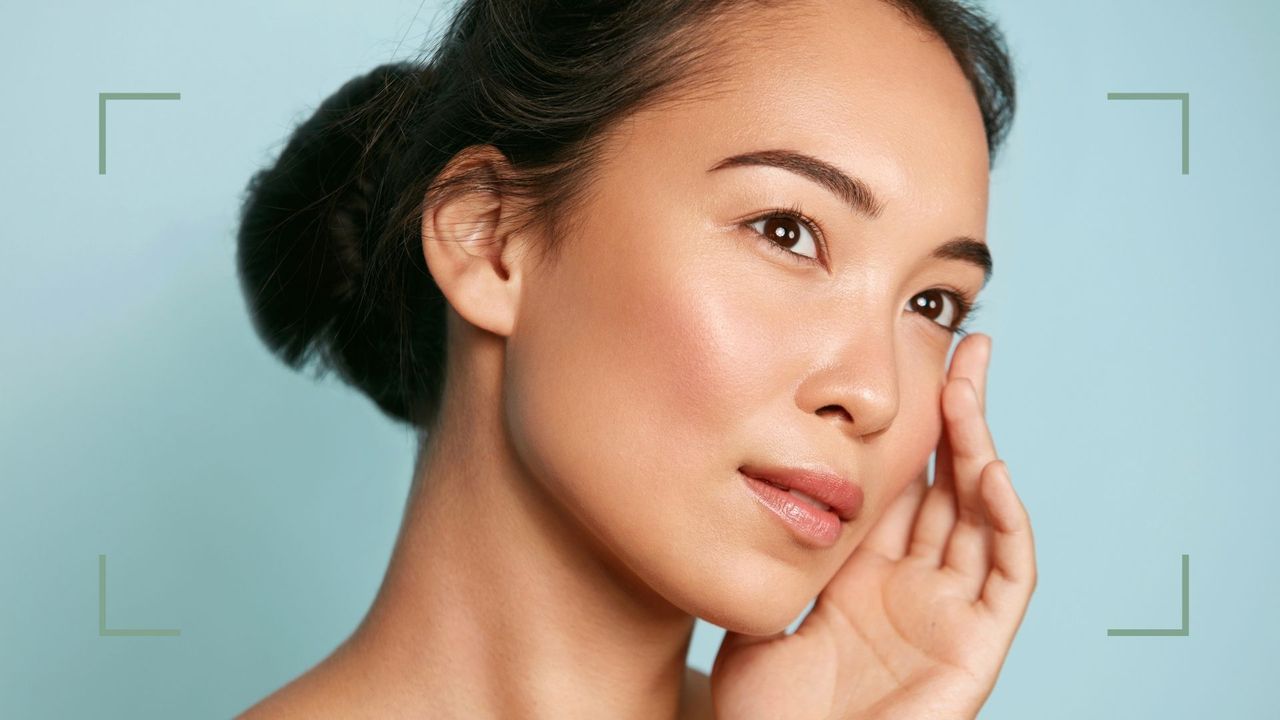 A woman with dehydrated skin touching her face on a blue background