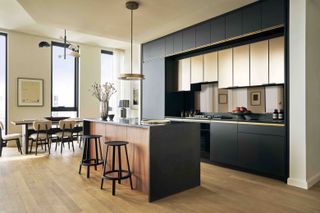 Black and wooden kitchen with island and black round bar stools
