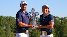 Marc Leishman and Cameron Smith hold a trophy