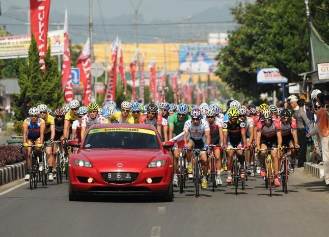 Riders wait for race officials to drop the flag on Stage 2