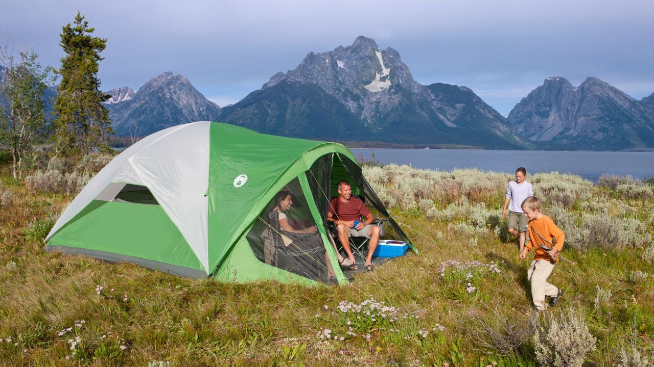 A young family camping in a national park with the Coleman Evanston Screened Tent