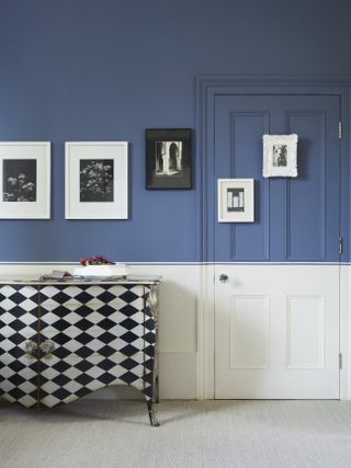 A wall featuring a door both painted half blue and half white