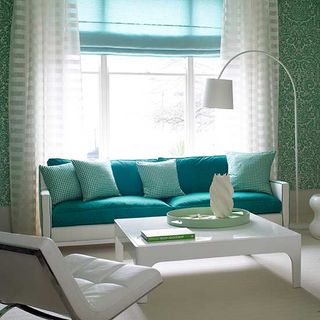 living room with printed green wall and sofa set with printed cushions