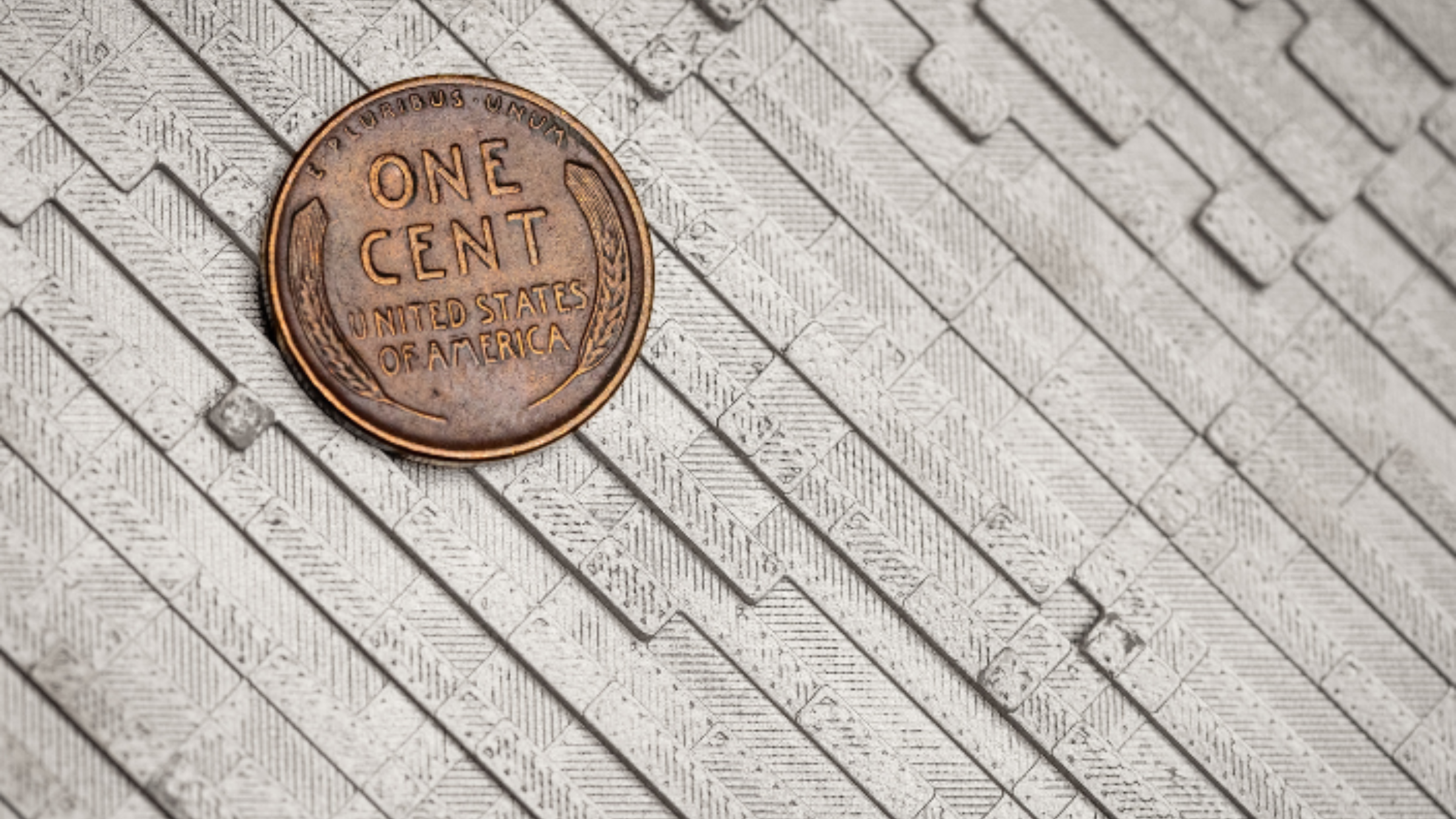 One cent coin amid small gray panels.