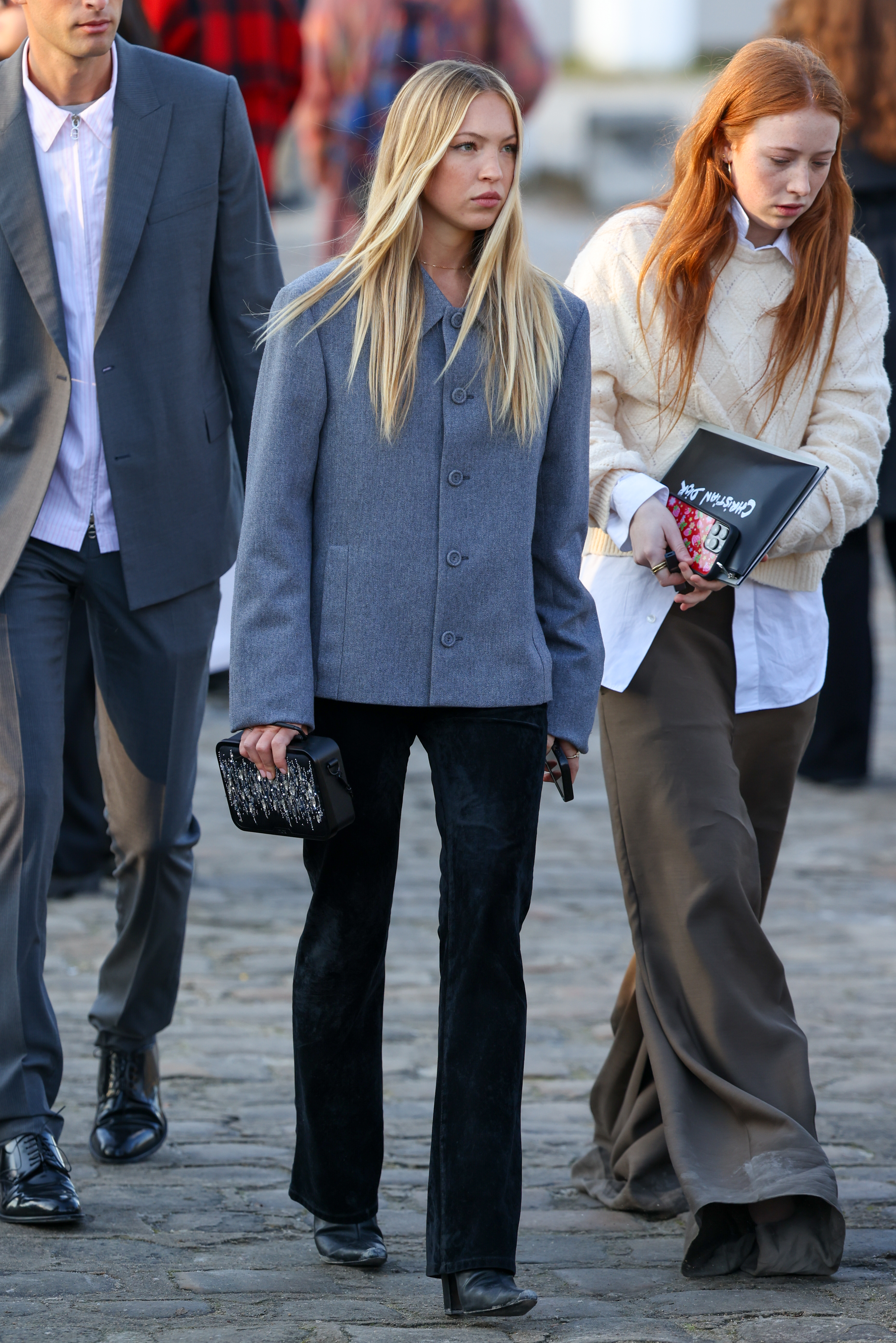 Lila Moss styles a a grey jacket and black trousers.