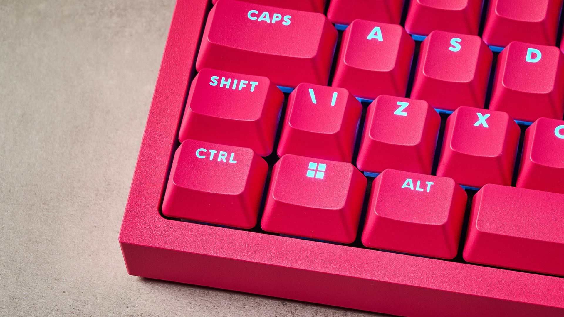 A photo of the Logitech G Pro X2 Rapid keyboard in hot pink on a stone surface