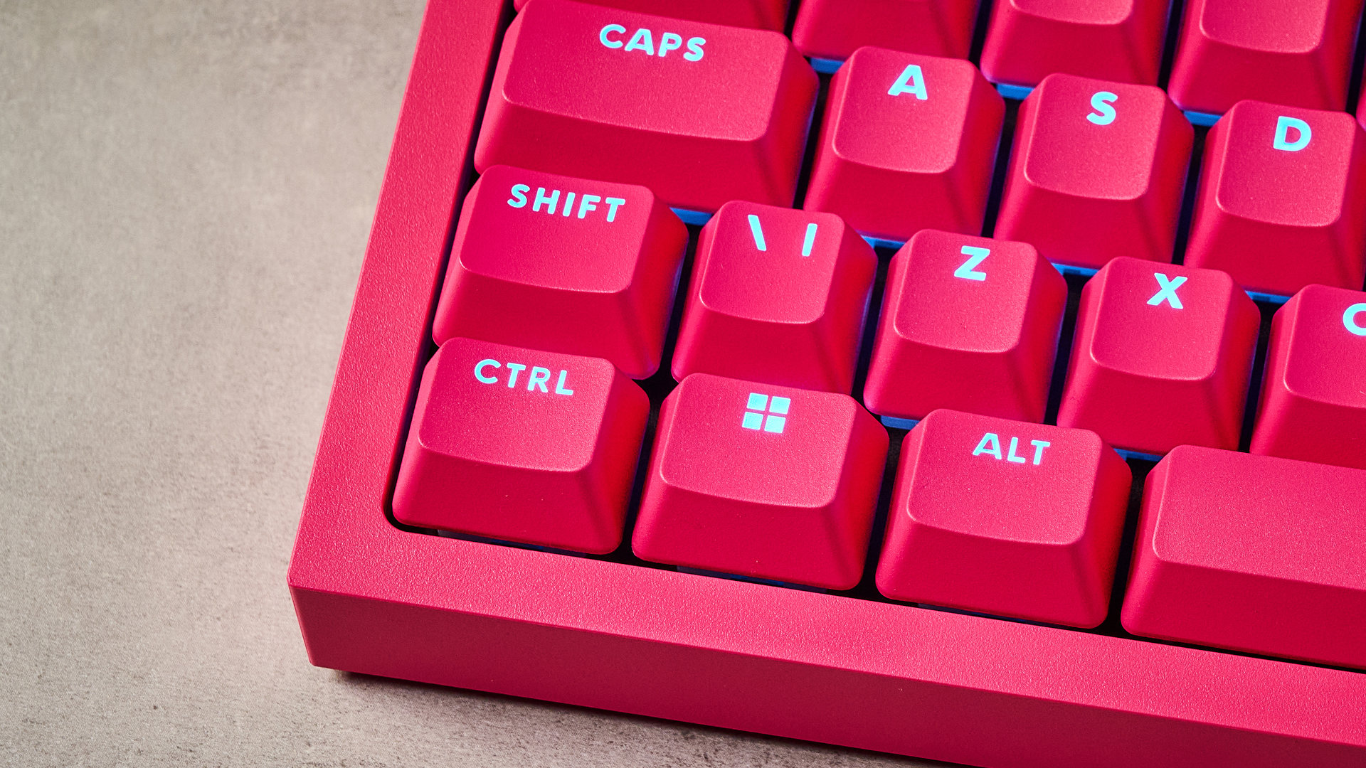 A photo of the Logitech G Pro X2 Rapid keyboard in hot pink on a stone surface