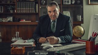 Roy sits sternly at his desk at the Corby Borough Council in Toxic Town