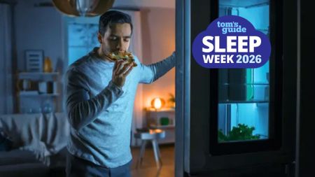 The image shows a dark-haired man standing at his fridge, holding a slice of pizza to his mouth with the fridge door still open. Overlaid on top of the image in the top left hand corner is a blue cloud-shaped badge that read Tom's Guide Sleep Week 2026. 
