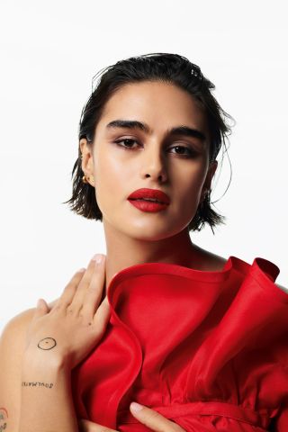 Model wearing Valentino Beauty red lipstick in red dress