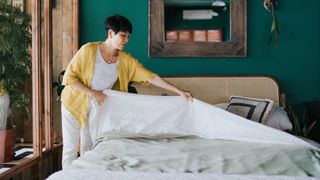 A woman makes her bed