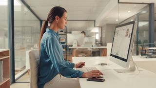 woman working on website on Mac, in office