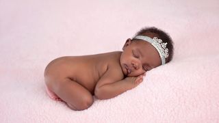 Newborn baby with crown asleep