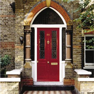 brick wall and red door with white frame