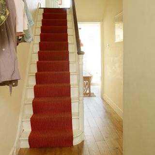 hallway with stairway and red carpet