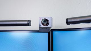 A close up shot showing the Obsbot Meet 2 webcam between two monitors