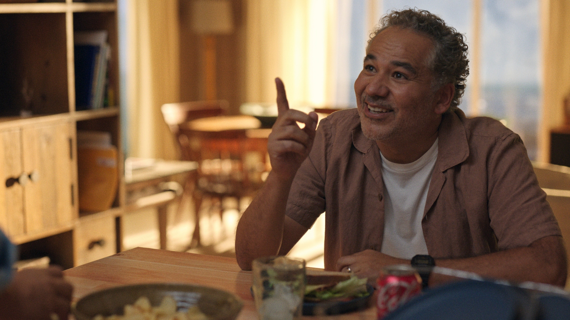 Rogelio points his finger and smiles in Bad Monkey