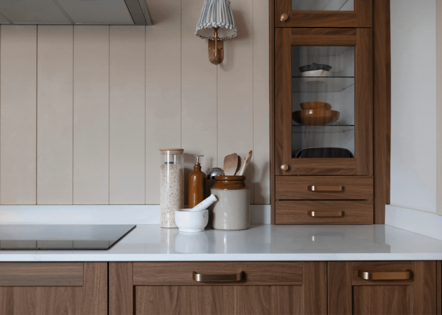 A gif of an IKEA kitchen with dark wood cabinets and a bright white quartz countertop. There is also kitchen essentials on the countertops.