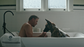 Channing Tatum and a dog sit in a bathtub
