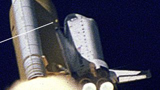 An arrow points to a piece of foam liberated from the external tank, which next strikes the leading edge of space shuttle Columbia's left wing, sealing the fate of the STS-107 crew on board.