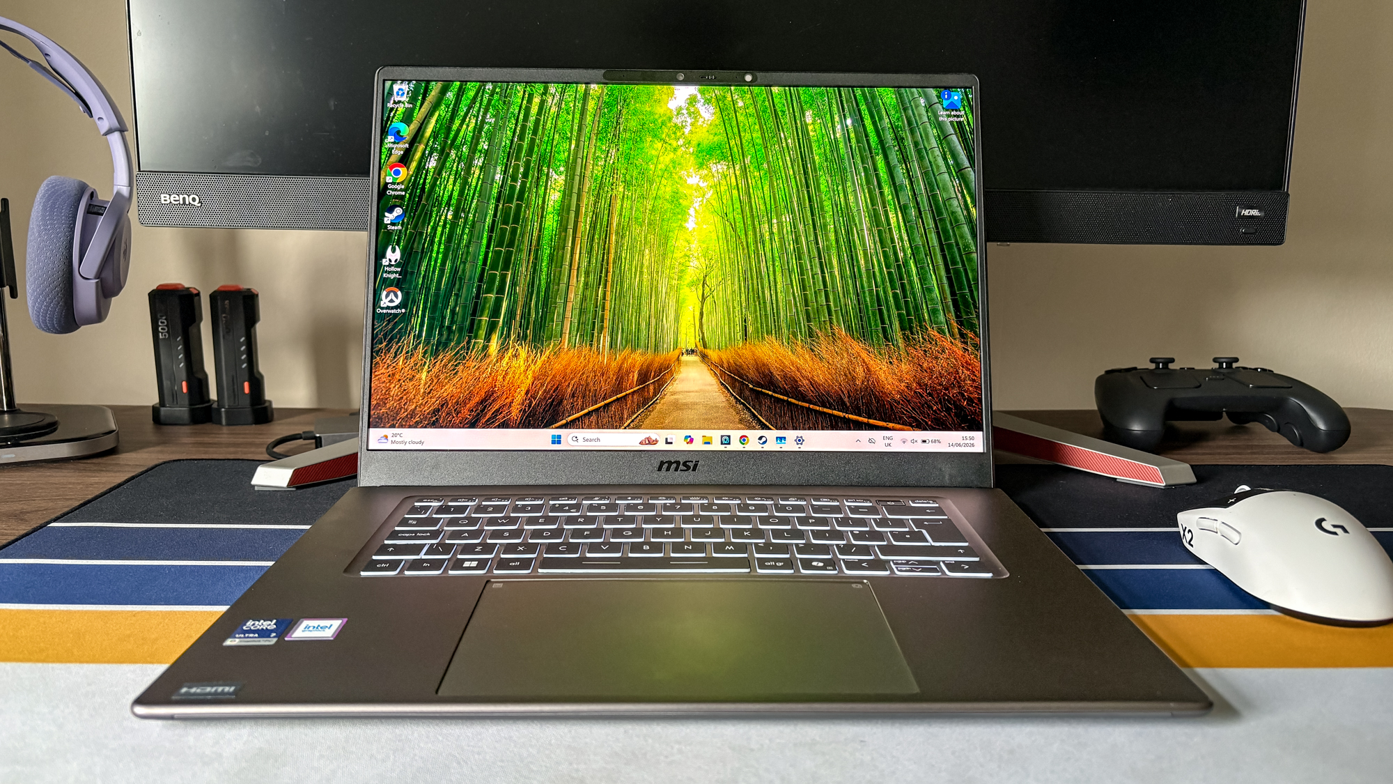 MSI Prestige 16 AI+ on desk with mouse, controller and headphones in background